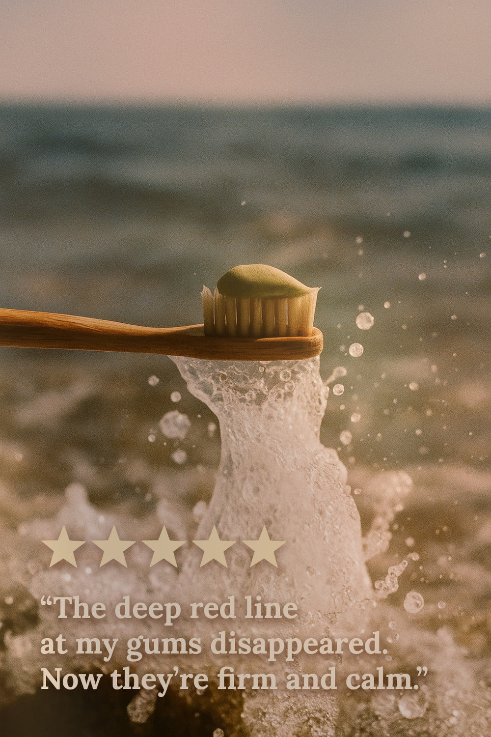 A bamboo toothbrush with green gum paste from Miracle of the Sea, held over ocean waves to highlight its natural marine-based oral care ingredients.